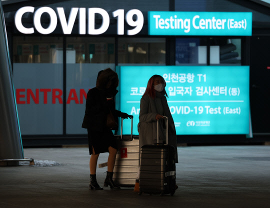 중국이 해외발 입국자 시설격리를 다음 달 8일부터 폐지하기로 한 가운데 28일 인천국제공항 제1여객터미널 코로나19 센터 앞으로 탑승객들이 지나고 있다.  연합뉴스